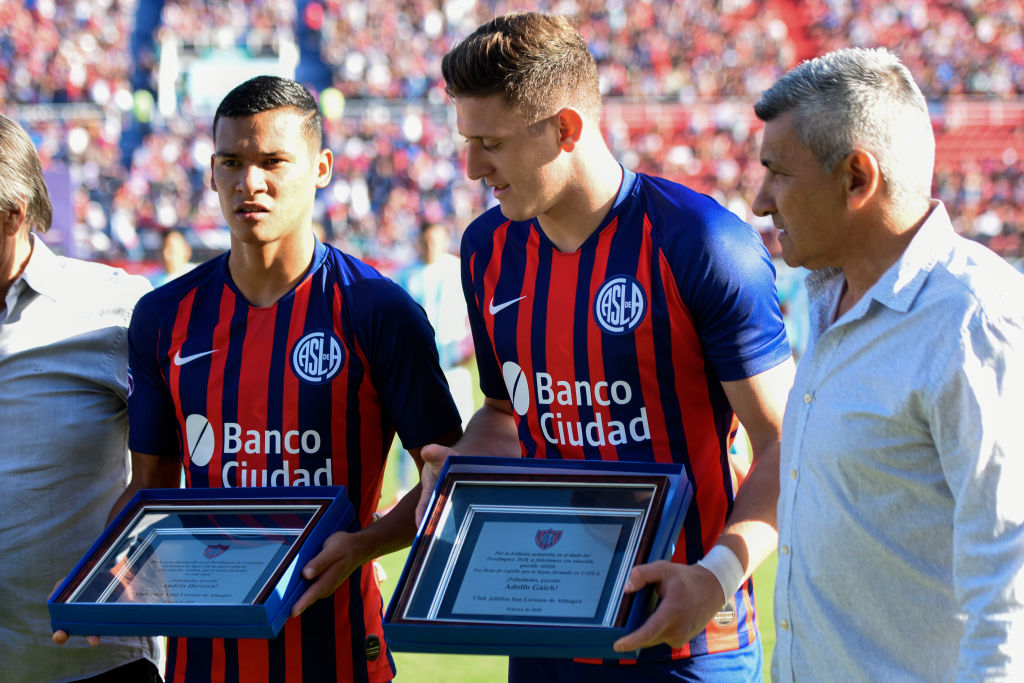 Julian Palacios and Adolfo Gaich of San Lorenzo receive a plaque for their win at the Olympic qualifiers with Argentina national team along with Alberto Acosta before a match between San Lorenzo and Racing Club as part of Superliga 2019/20 at Estadio Pedro Bidegain on February 22, 2020 in Buenos Aires, Argentina. Photo by Rodrigo Valle/Getty Images